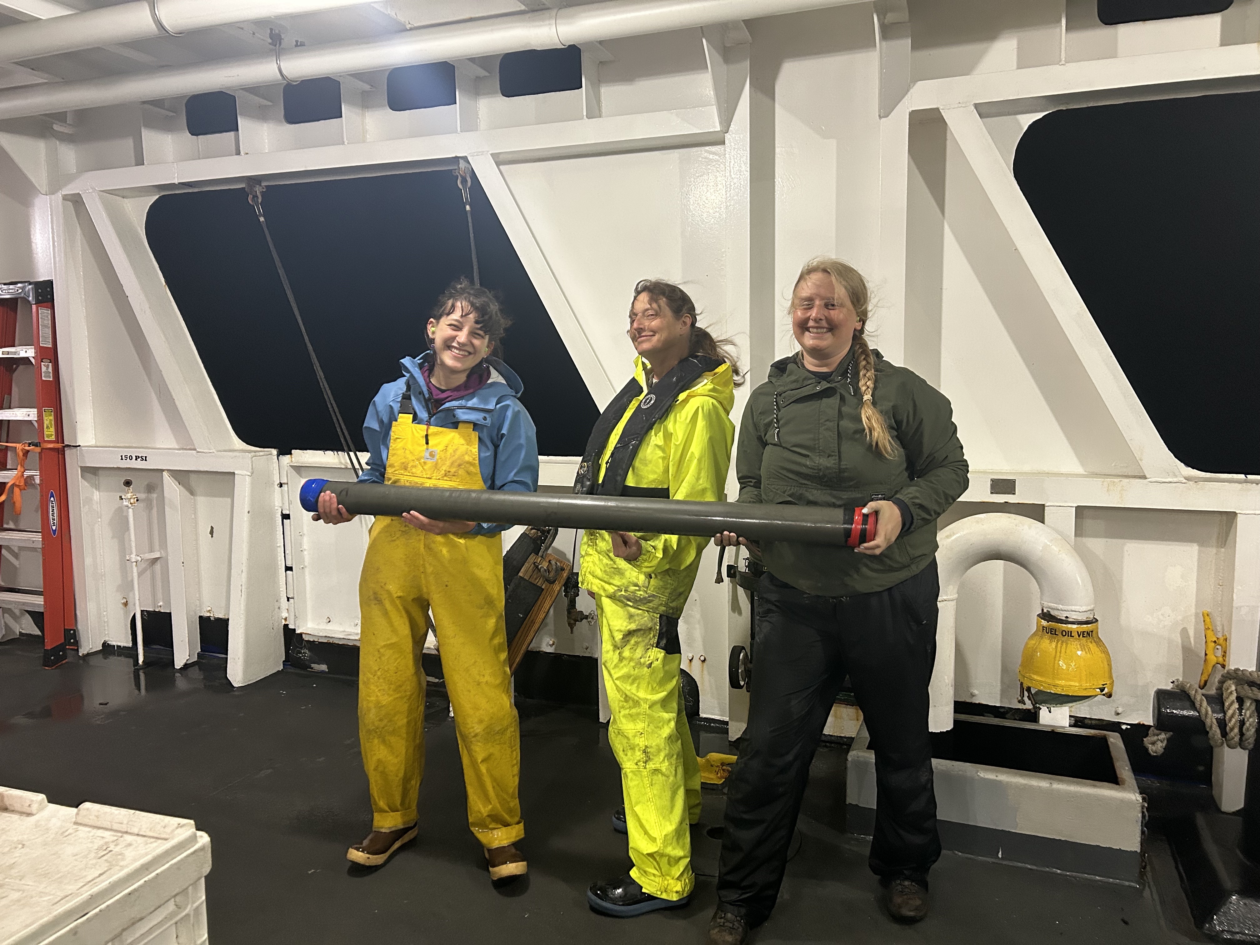Anna Ledeczi, Janet Watt, and Madeleine Lucas with a section of a collected sediment core.
